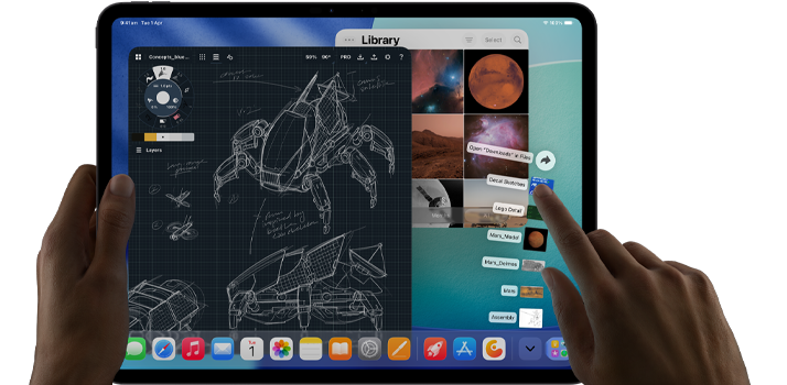 iPad Pro, space black colour, left hand holding device, right hand pointing gesturing to manipulate multiple open app windows, a drawing app with sketches of mechanical designs, photos library of planets and space images, downloads folder files fanned out